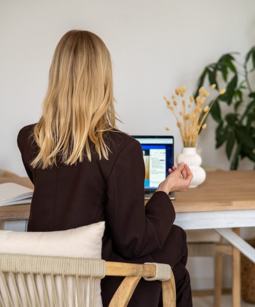Frau sitzt ruhig an einem Schreibtisch und arbeitet konzentriert in einer klaren, minimalistischen Umgebung